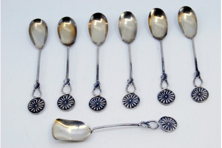 Conjunto de seis colheres de café e pá de açúcar em prata com os cabos recortados e relevados. 